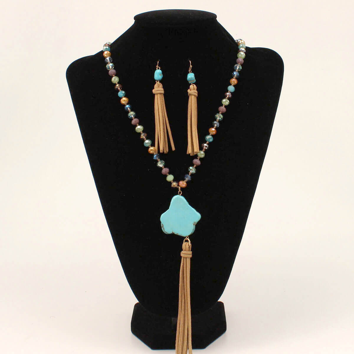 This beautiful necklace set features multi colored shimmer beads with a turquoise stone pendant and a brown suede tassel. Comes with matching earrings, wear them together or separate to elevate that outfit. Measures 24" long. Imported. 