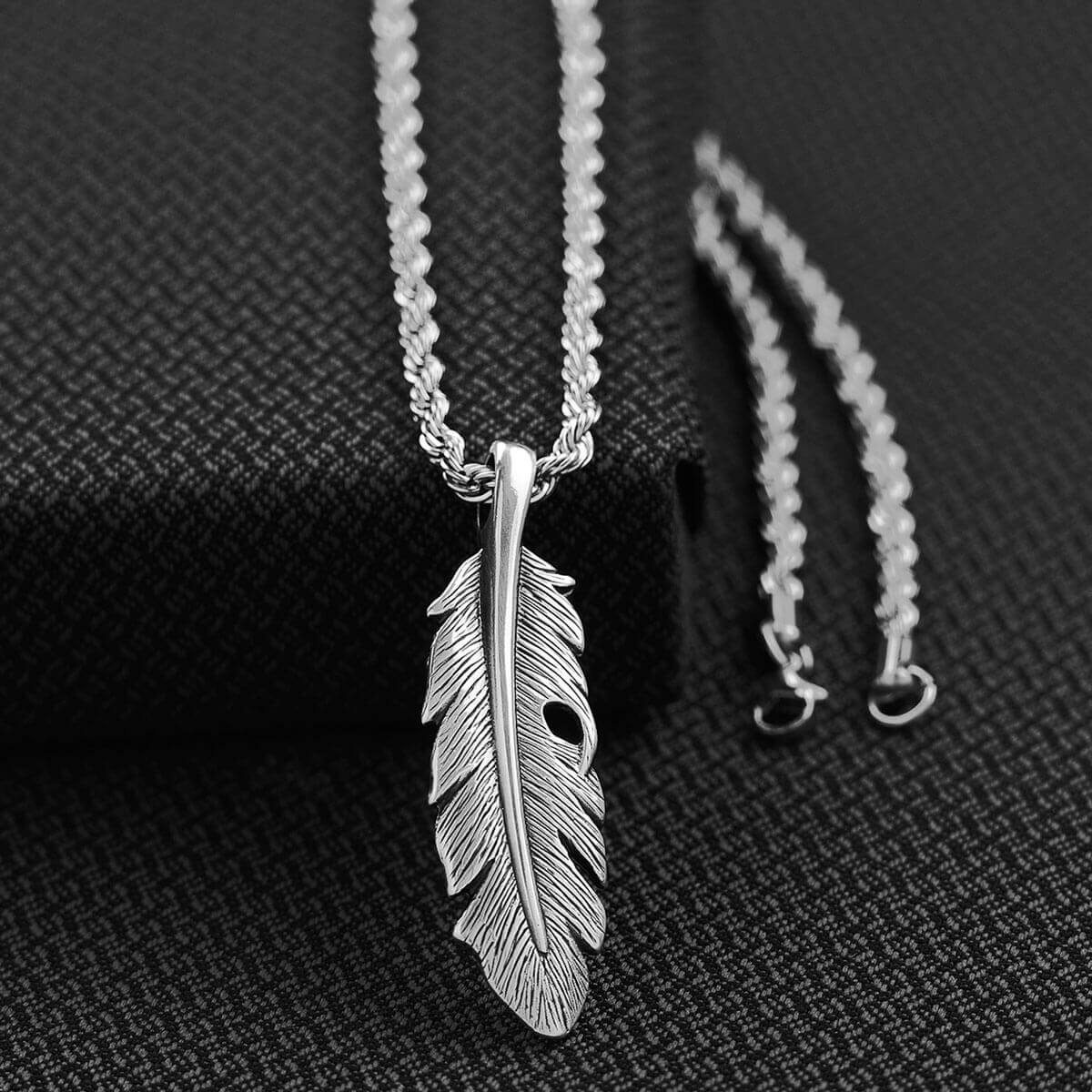 This Twister men's chain necklace features a feather pendant. This beautiful pendant rests on a 24" long silver colored chain. Pendant measures about 2-1/2" long by 3/4". Imported
