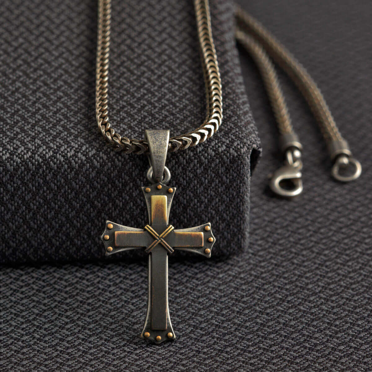 This chain necklace has a very edgy look. The 22" chain is a small rope style with a 3 dimensional gold/silver cross about 2" long by 1-1/4" wide. Made of Silver Plated Zinc (Nickle, Lead and Cadmium free). Designed in USA. Made in Taiwan.