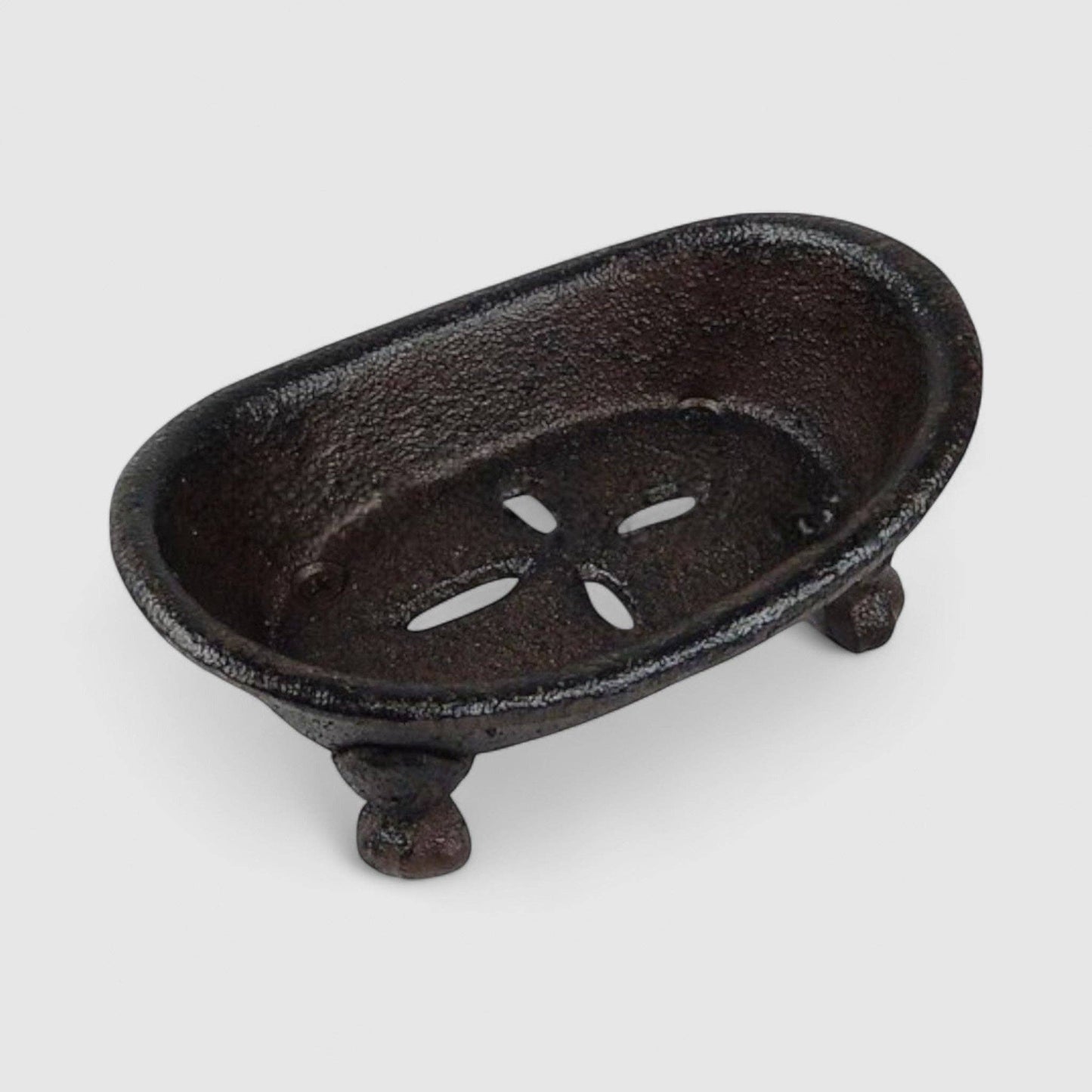 Cast iron soap dish with decorative cutouts on a white background