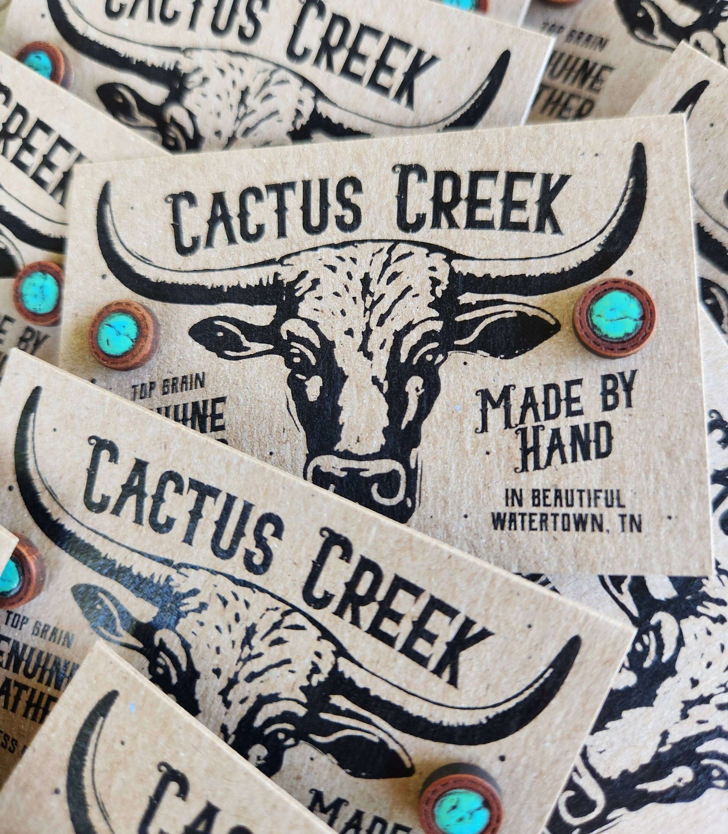 Stack of Cactus Creek branded product labels with a bull illustration.