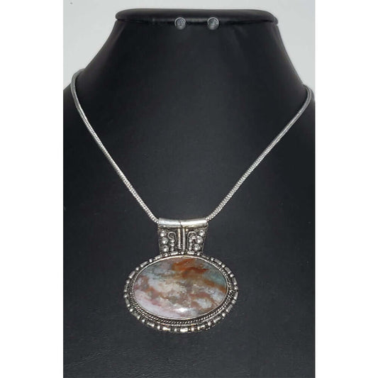 Agate oval pendant with a silver tone frame on a snake link chain. Necklace measures 21″ with a lobster claw clasp and extension. 