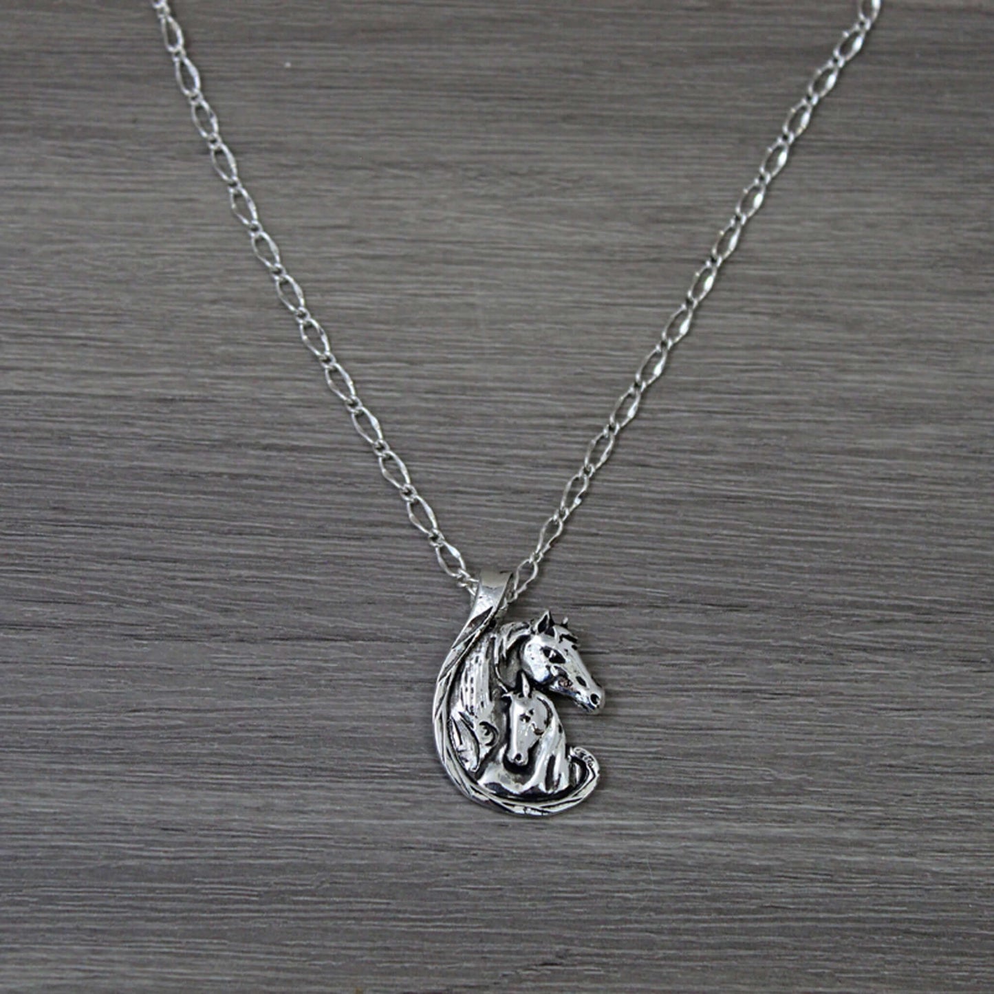 A special necklace perfect for a mother, daughter or lady in your life to show them how much they mean to you. Two horses embrace love and affection on an 18" chain. Pendant measures 1-1/4" tall by 1" wide.
