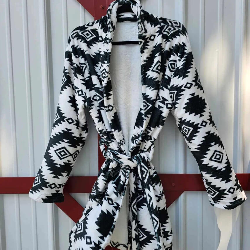 Aztec Women's Western Bath Robe hanging on display, featuring a striking black and white Aztec pattern.