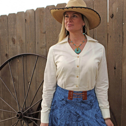 Woman wearing a Buckaroo Western Blouse with a stylish hat and blue skirt, showcasing a timeless and classy look.