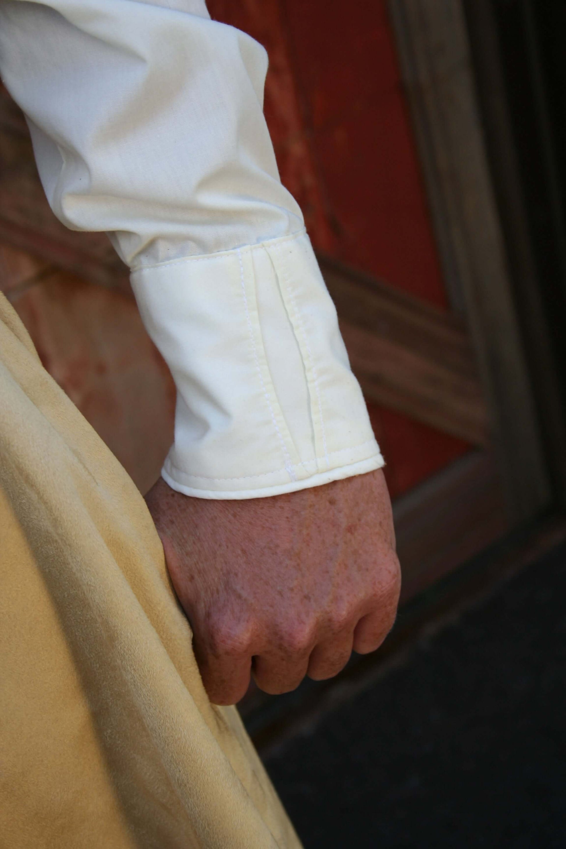 Close-up of a white long-sleeve blouse cuff with a keyhole design, showcasing stylish western blouse details.