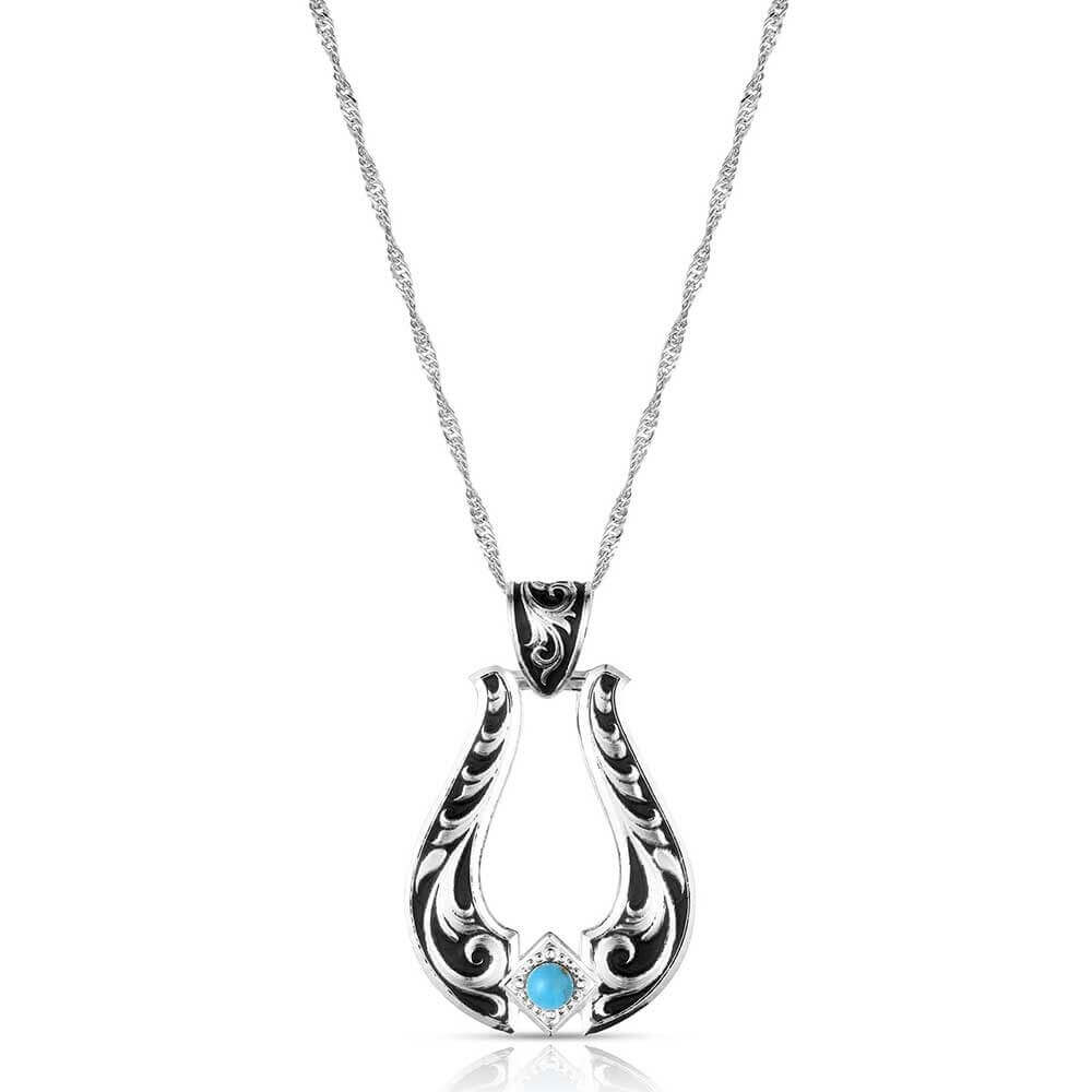 Honoring Miss Rodeo America 2025, Callie Mueller, we present Callie's Turquoise Trail Necklace. This pendant is crafted with a silver tone base and detailed filigree throughout. Black paint adds contrast and depth, highlighting every curve and engraving. At the base, a crafted turquoise stone is set within a delicate beaded edge, bringing a pop of natural color and timeless character. Pendant measures about 1-1/4" by 1-3/4" and on a 19 inch adjustable chain.