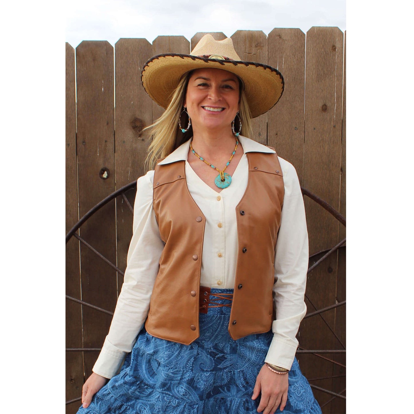 Whether you are attending your local Rodeo or saddling your horse, you’ll look fierce yet feminine in this all leather vest. This soft leather vest is styled with front and back yokes decorated with copper hammered studs. Two front pockets to keeps your necessities in and a front copper snap closure. Made of Lamb leather in a rich tobacco color and lined in polyester. Made in USA. Dry Clean.
