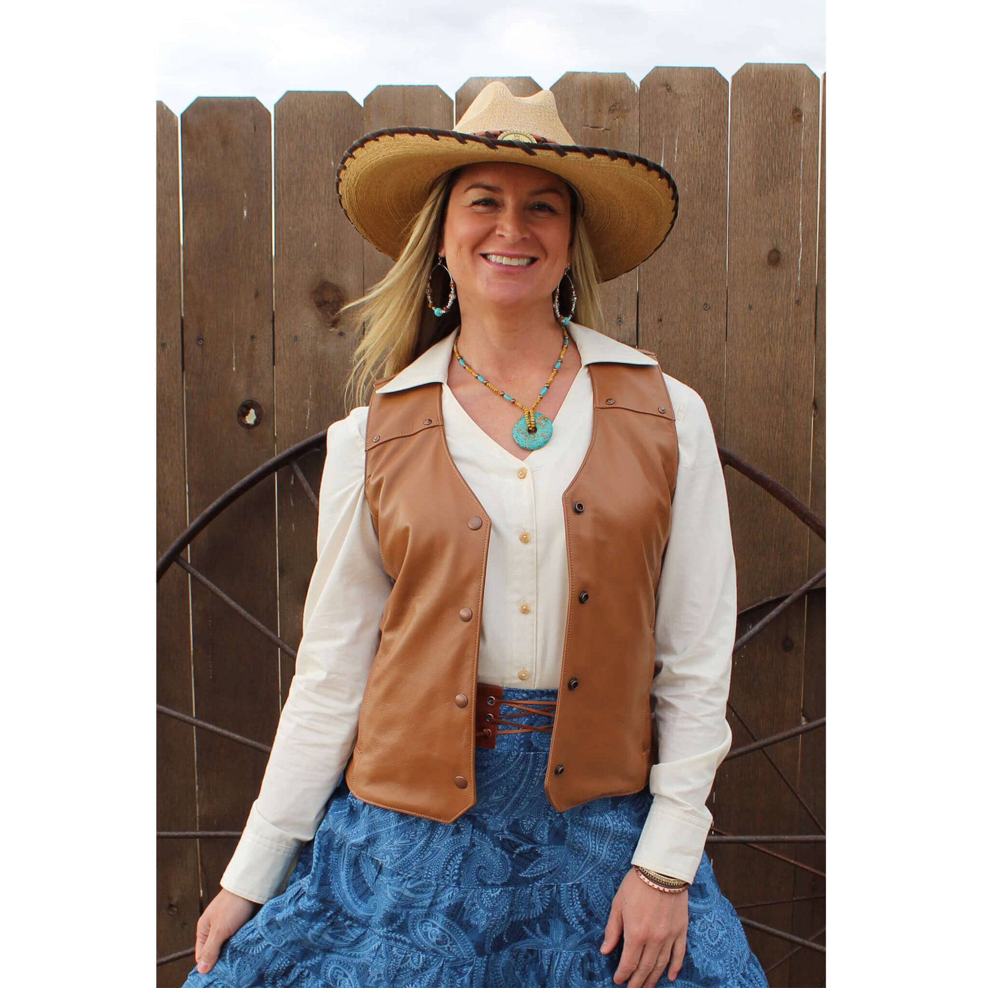 Whether you are attending your local Rodeo or saddling your horse, you’ll look fierce yet feminine in this all leather vest. This soft leather vest is styled with front and back yokes decorated with copper hammered studs. Two front pockets to keeps your necessities in and a front copper snap closure. Made of Lamb leather in a rich tobacco color and lined in polyester. Made in USA. Dry Clean.