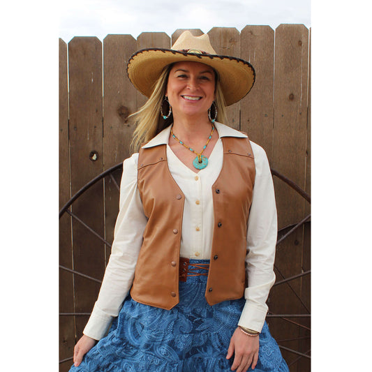 Whether you are attending your local Rodeo or saddling your horse, you’ll look fierce yet feminine in this all leather vest. This soft leather vest is styled with front and back yokes decorated with copper hammered studs. Two front pockets to keeps your necessities in and a front copper snap closure. Made of Lamb leather in a rich tobacco color and lined in polyester. Made in USA. Dry Clean.