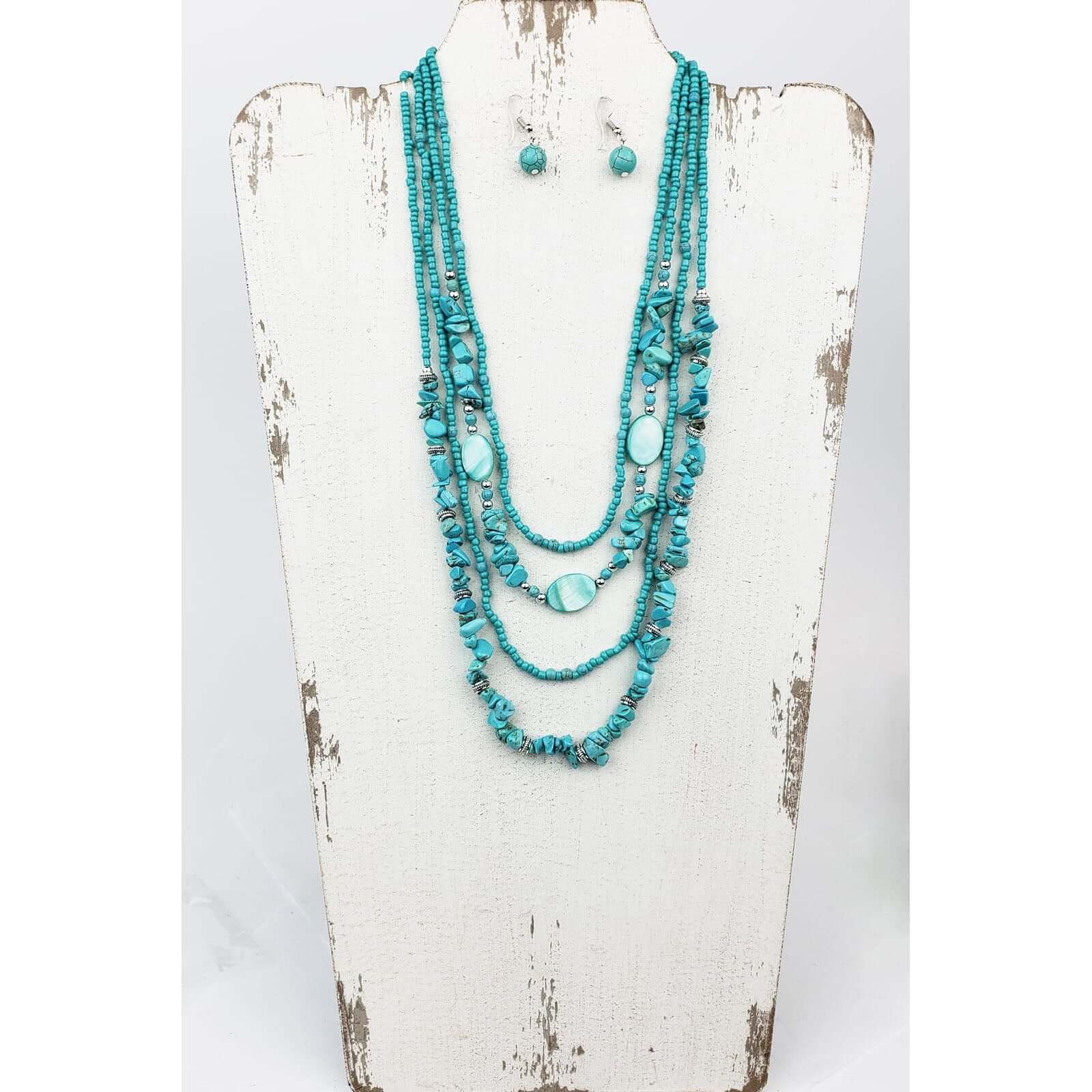 For turquoise and ocean lovers alike. Four layered strands of mag turquoise beads and stone. Longest strand measures 22″ with lobster claw clasp and extension chain. Matched with hypoallergenic ear wires holding a mag turquoise bead.