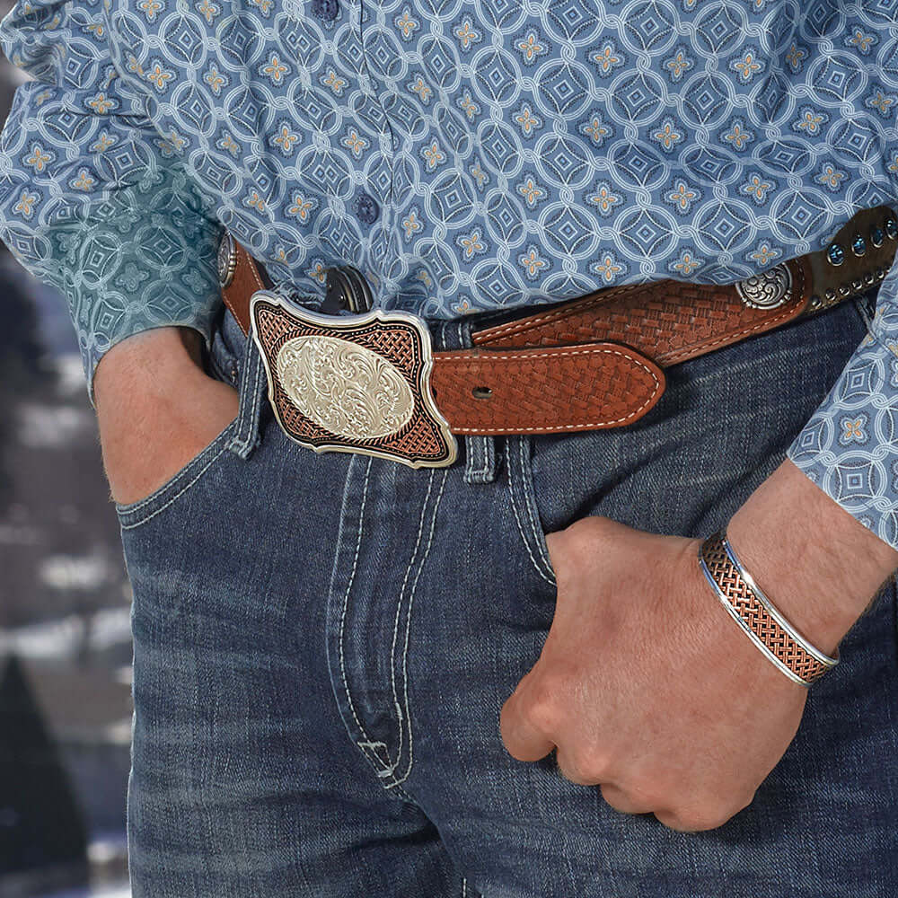 Man wearing Classic Copper Weave Crossing Cuff Bracelet with a patterned shirt and leather belt.