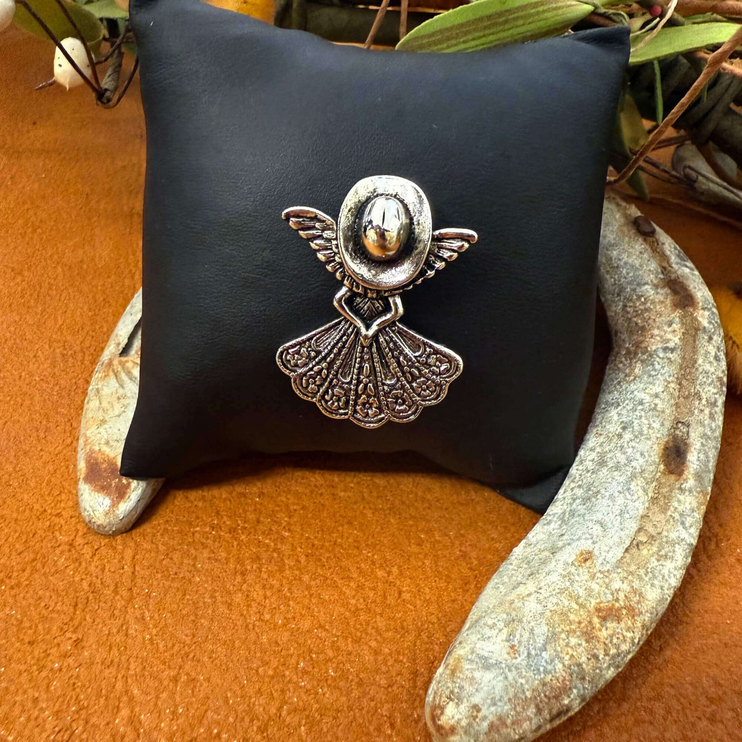 Decorative brooch on a black cushion with a natural background