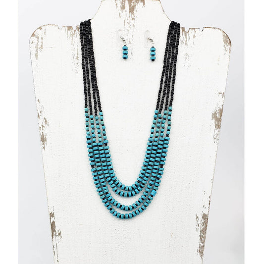 Matches perfectly with a bracelet to create a dream set of turquoise. Four black beaded strands leading to groups of alternating black and turquoise Howlite beads. Longest strand of necklace measures 26.5ā³ with lobster claw clasp and extension. Matched with hypoallergenic ear wires holding alternating black and turquoise Howlite bead