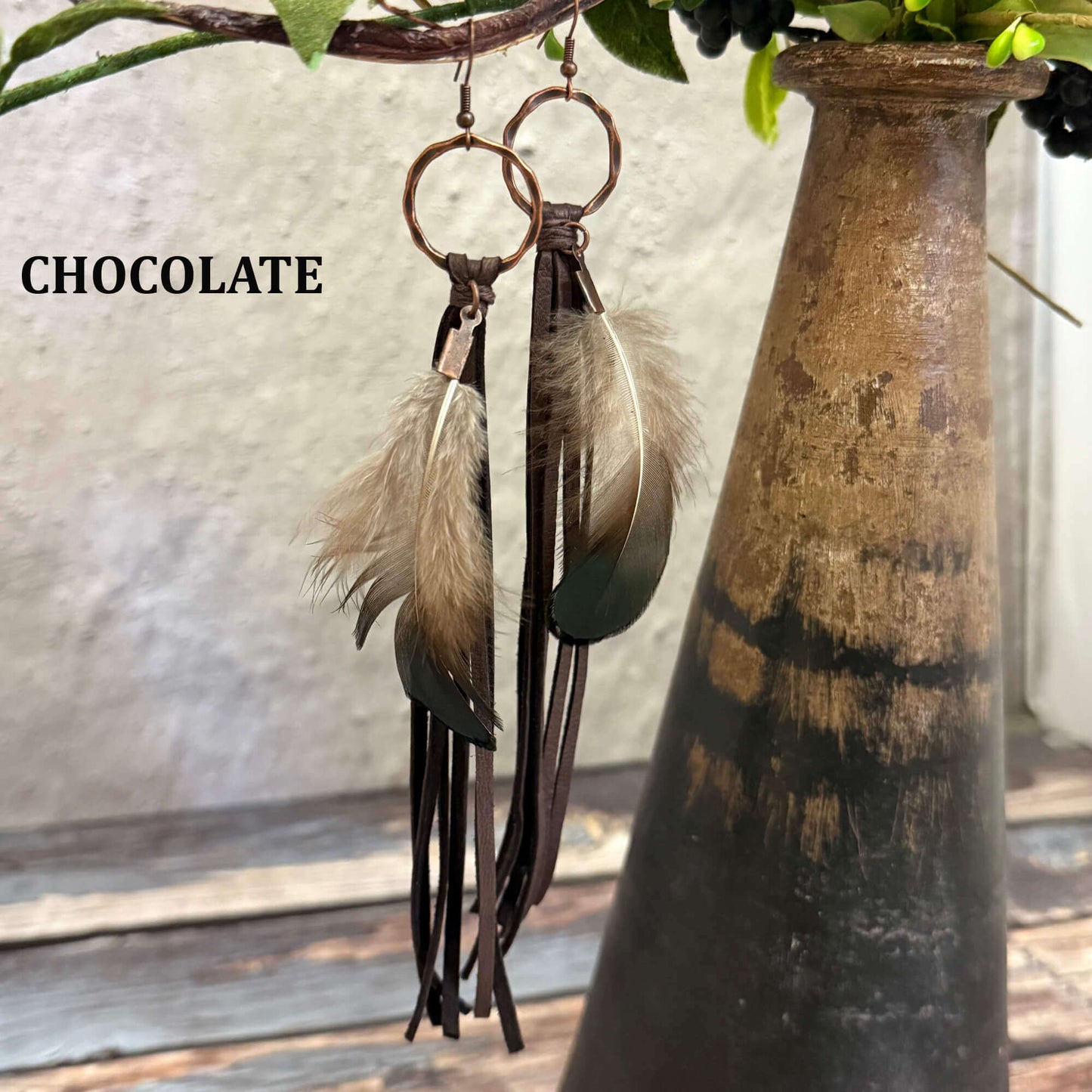 Feather and Leather Tassel Western Earrings featuring chocolate leather and feathers hanging from copper hoops.