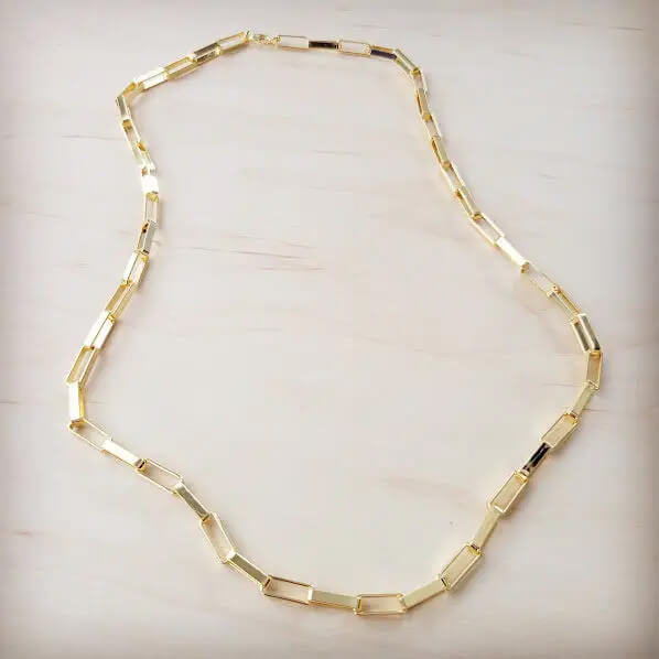 Gold necklace on a light beige background