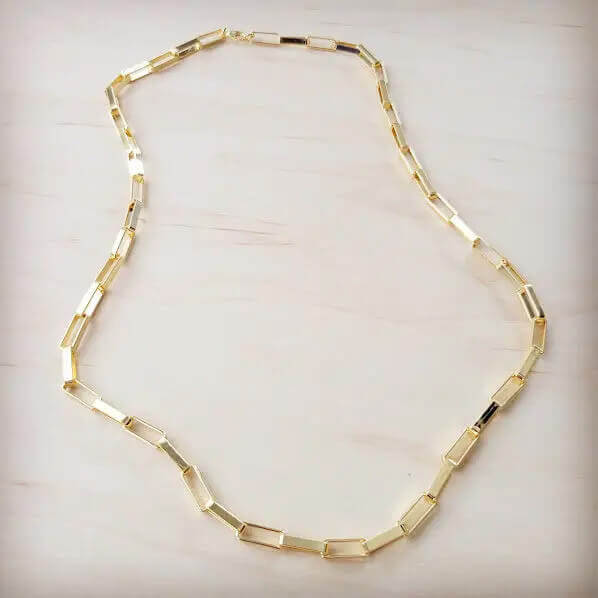 Gold necklace on a light beige background