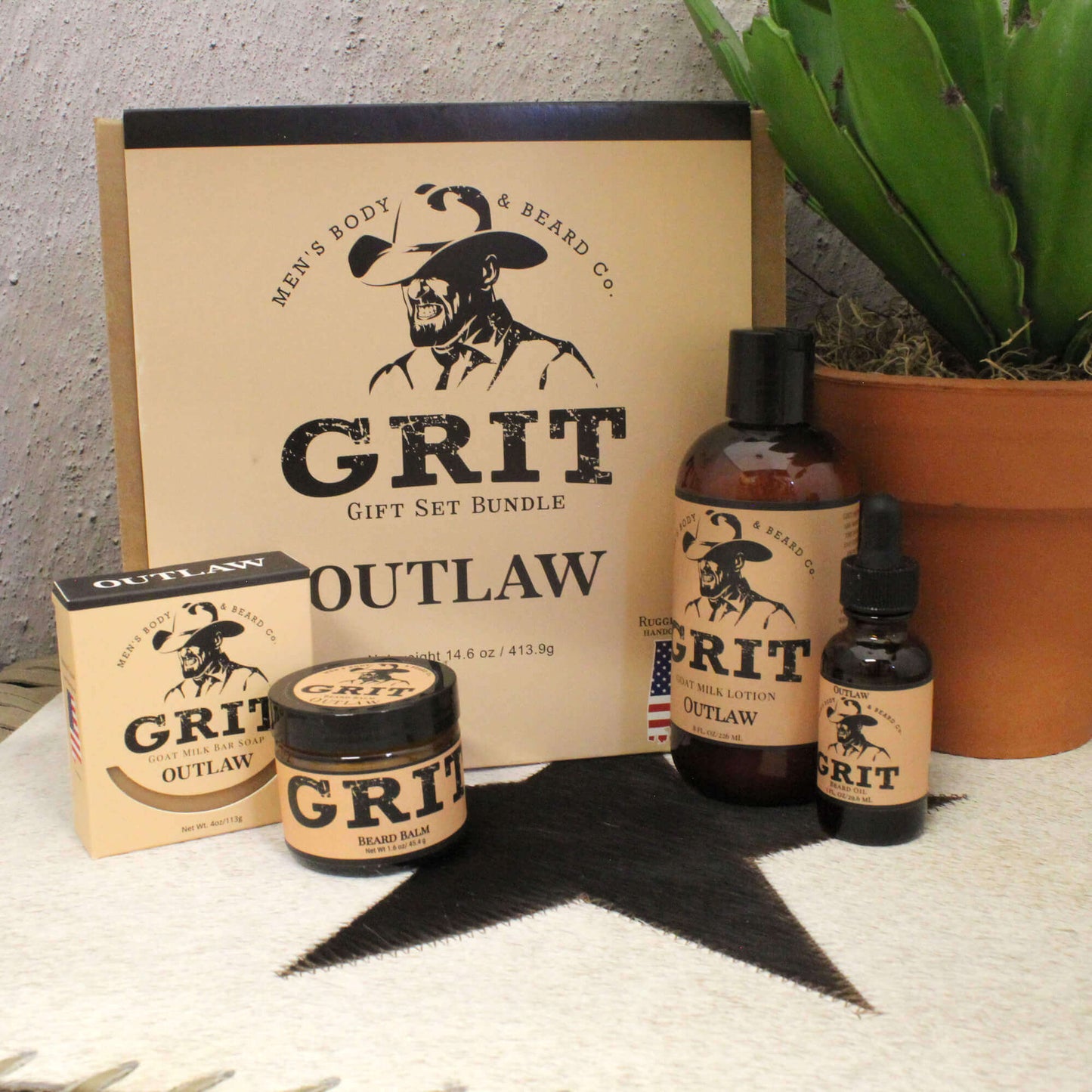 Grit Outlaw gift set bundle with bottles, jar, and box on a textured surface with a plant in the background.