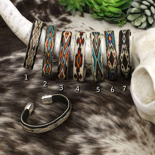 Vibrant colors and elaborate designs highlight these hitched horsehair cuff bracelets. These flexible bracelets will be the envy of all your friends. Flower etched silver ends add the finishing touch to these beautiful pieces. Order by color. Approximately 7" long. Patterns and colors vary slightly.