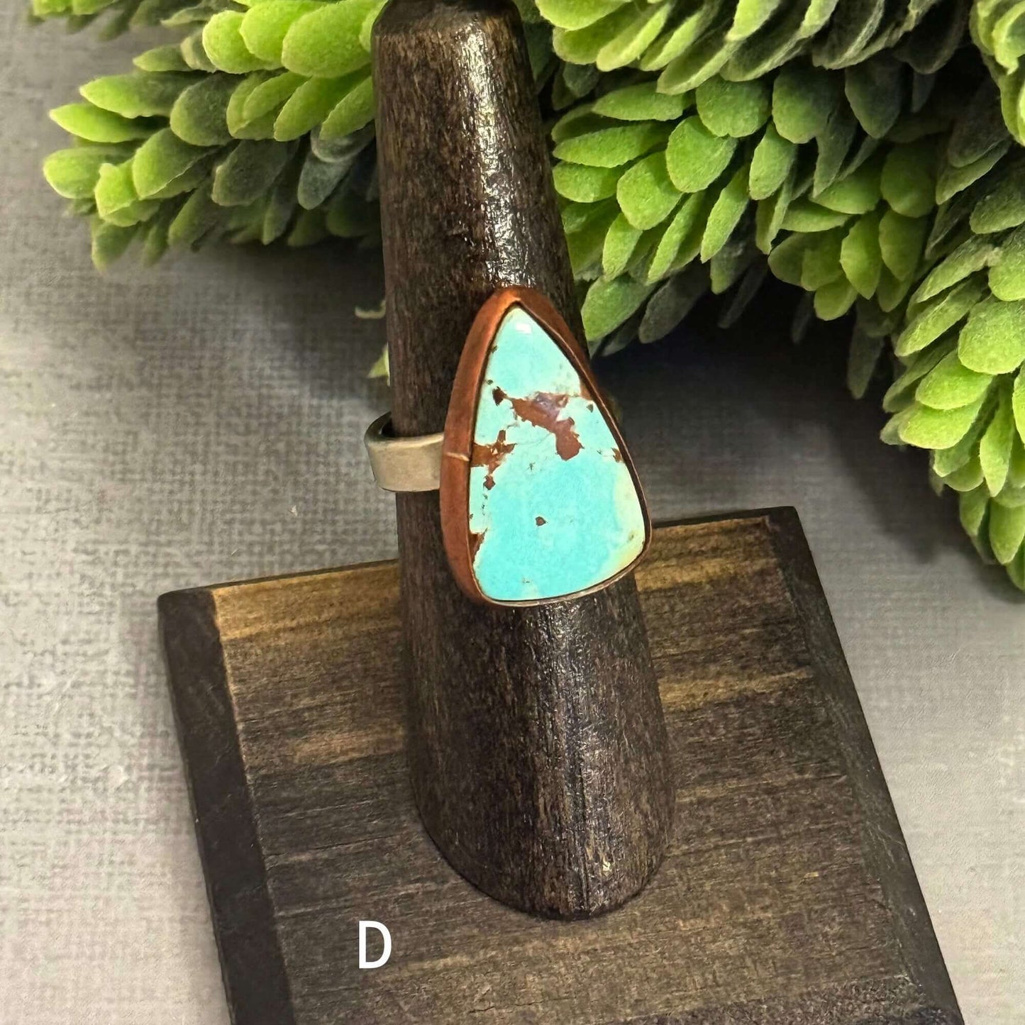 Handmade J Marie genuine turquoise ring on display with adjustable band, showcasing unique patterns and vibrant color.