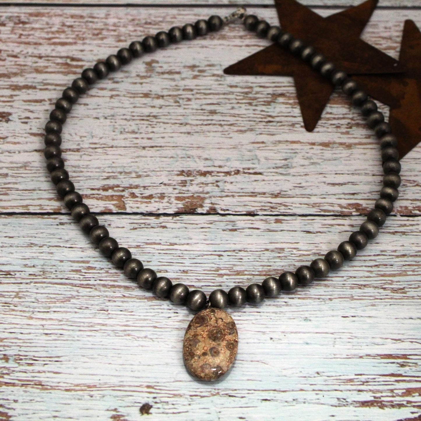 This necklace is the ultimate wardrobe staple. The simple, elegant design features a jasper stone pendant suspended from chrome beads, creating a look that's effortlessly chic. Slip it on to instantly elevate any outfit, from a basic tee and jeans to a little black dress. It's the perfect accessory to pull your look together with minimal effort. 18" length 