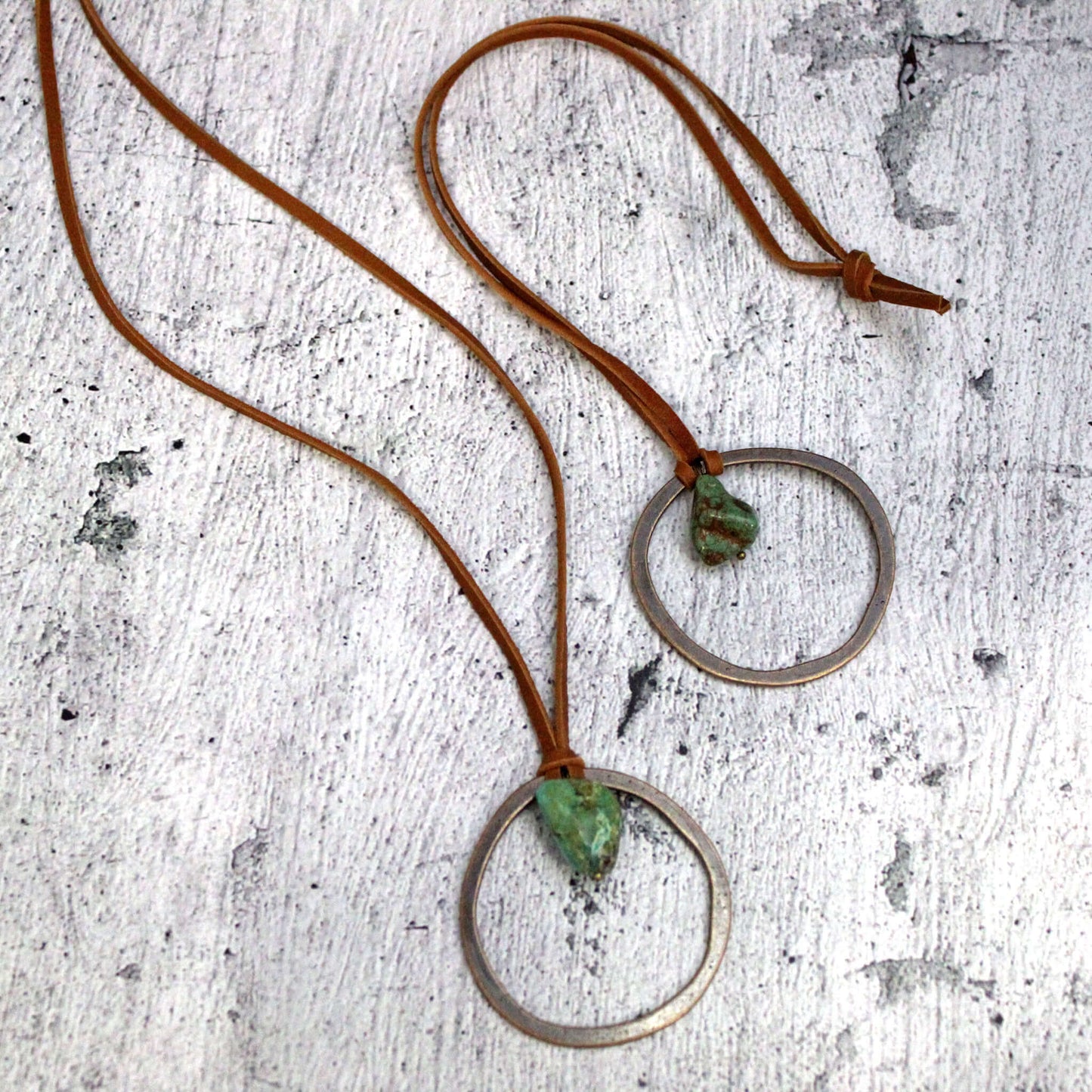 Genuine Leather Necklace is accented with a pendant of Turquoise. Great for layering or as a statement piece. Entire length of necklace is 28 inches Self-tie closure can be adjusted as needed. Pendant will vary in size from 1"-2" Although your item will resemble the photo, each piece is created by hand, so no two are identical.