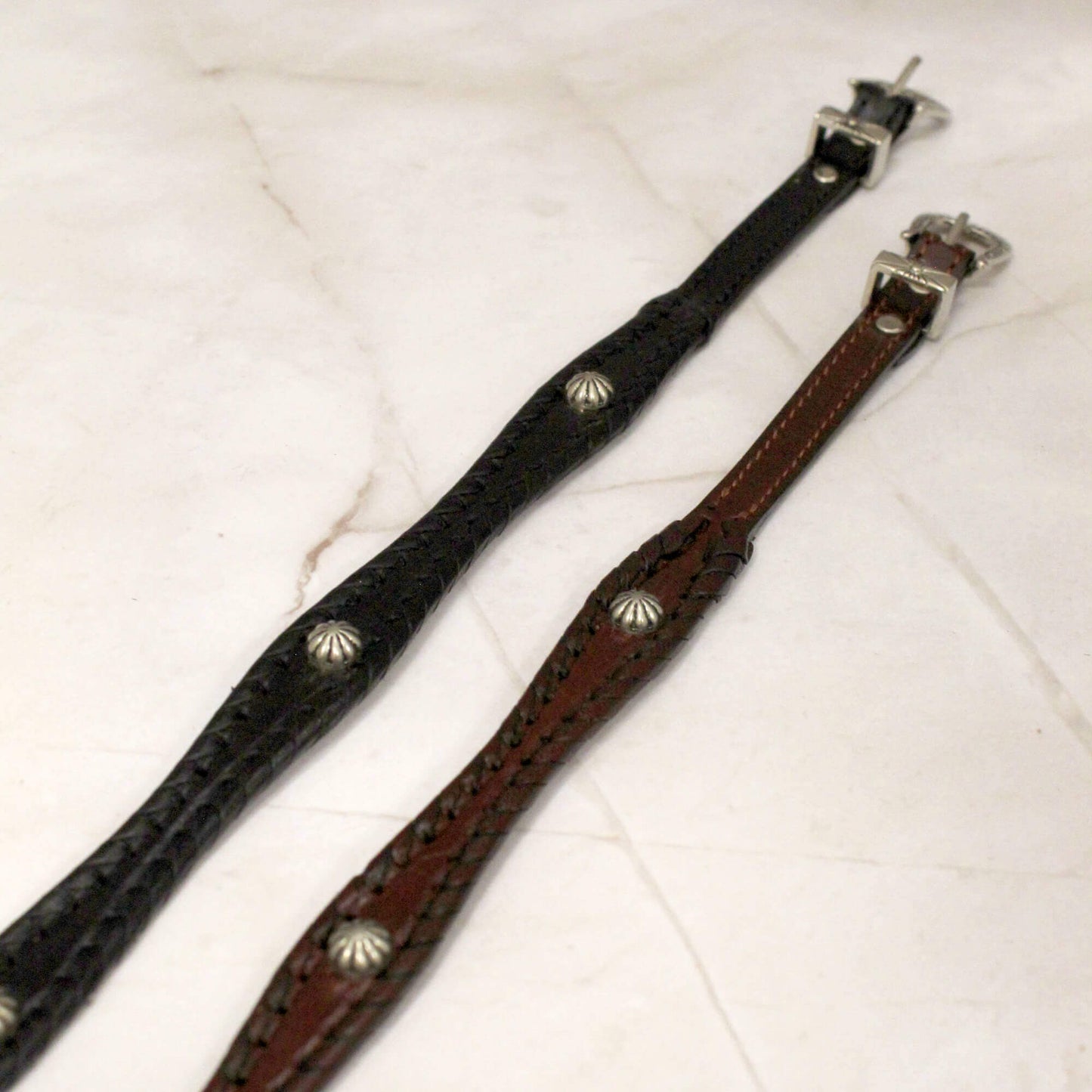 Show your western style with the Leather Cowboy Hatband with Studs - the perfect accessory to add a touch of rugged sophistication to any hat.
• Scalloped leather design with shimmering silver studs
• Adjustable silver western buckle closure to fit most hats
• Available in classic black or rich brown