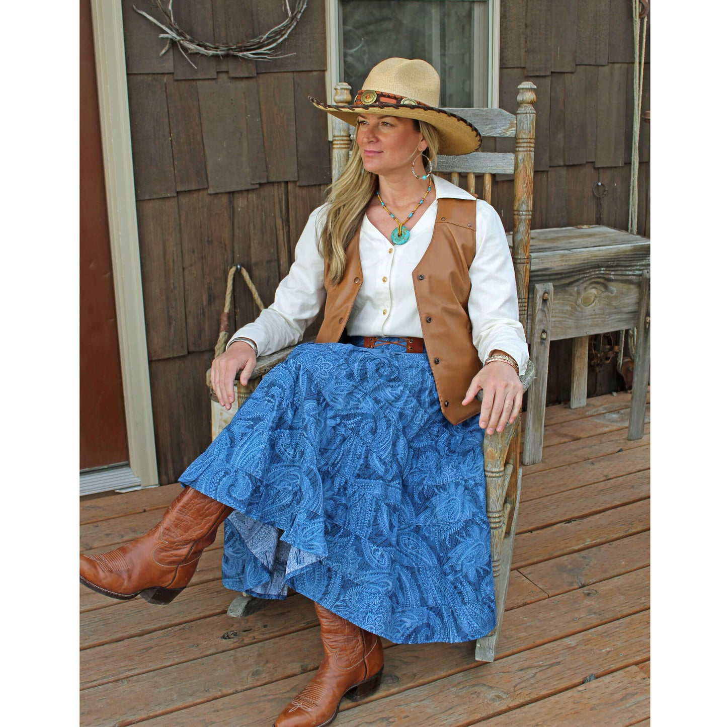 A great western skirt in the traditional "broomstick" style. Nine tiers of a blue on blue paisley print cotton. Features include a comfortable wide waistband with elastic in the back for a nice fit and a decorative leather trim and tie in the front.