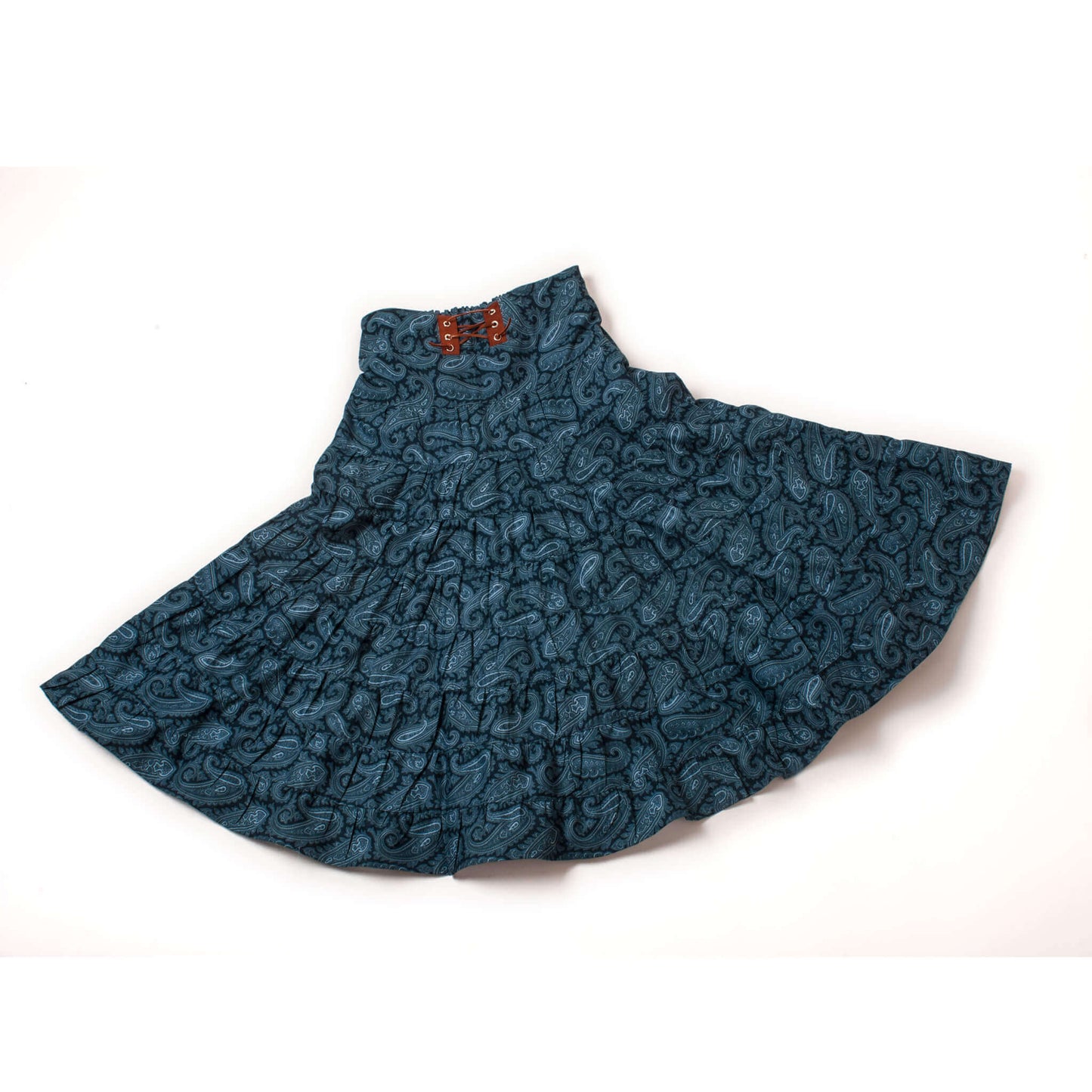 A great western skirt in the traditional "broomstick" style. Nine tiers of a blue on blue paisley print cotton. Features include a comfortable wide waistband with elastic in the back for a nice fit and a decorative leather trim and tie in the front.