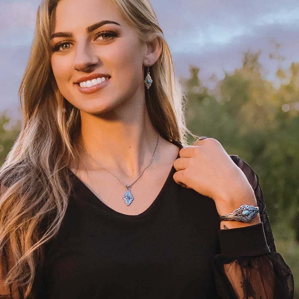 Model wearing Montana Skies Turquoise Cuff Bracelet with matching jewelry and a black top outdoors.