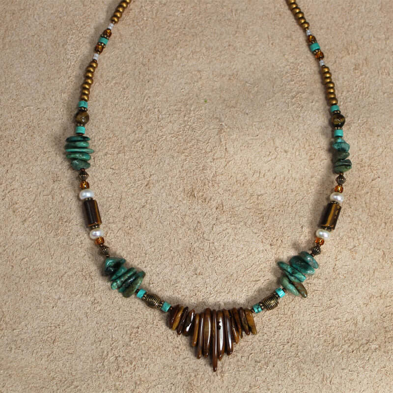 Tiger Eye spikes with mag turquoise ships and pearls, make this an interesting combination. Measures 22″ including a 4″ extender and lobster claw clasp. Each piece is unique and may vary slightly.