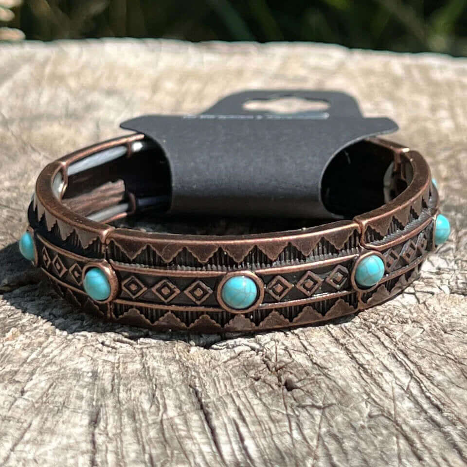 Brass and Turquoise goes hand-in-hand with the playful brass-plated elastic bracelet. Antique copper-colored bracelet with Aztec geometric pattern and turquoise-colored stones. Elastic band fits most wrists.