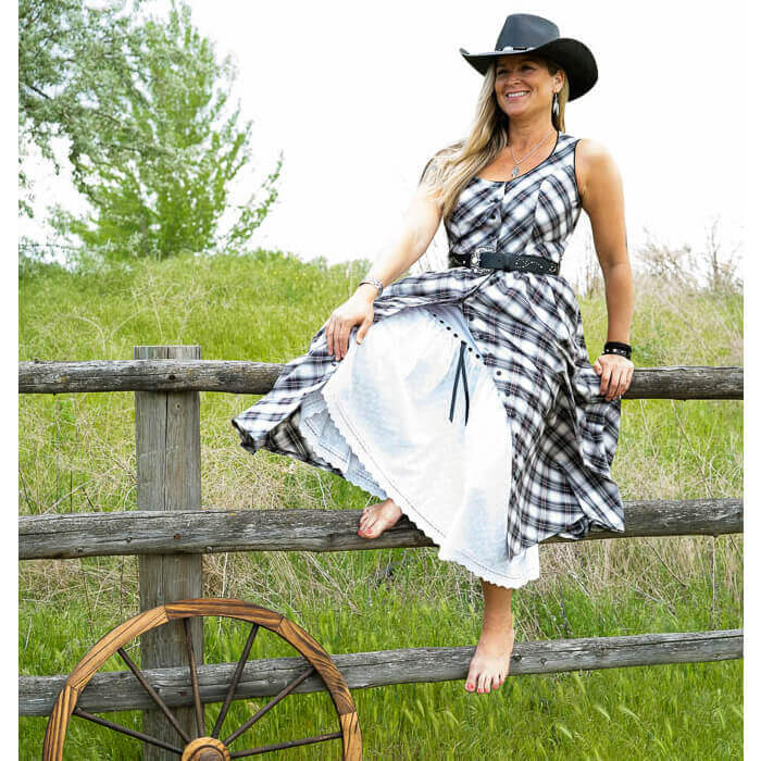 A flirty sundress baring just enough with its button-front and eyelet petticoat (sold separately) peeking out beneath. Contrast piping trims the neckline and armholes and comes with belt loops around the waist to accommodate a cute belt. Dress is made with a bias cut cotton plaid and bodice is lined for modesty. Measures 31” from waist down. 100% Cotton/Lined in Polyester. Petticoat Sold Separately. Made in USA
