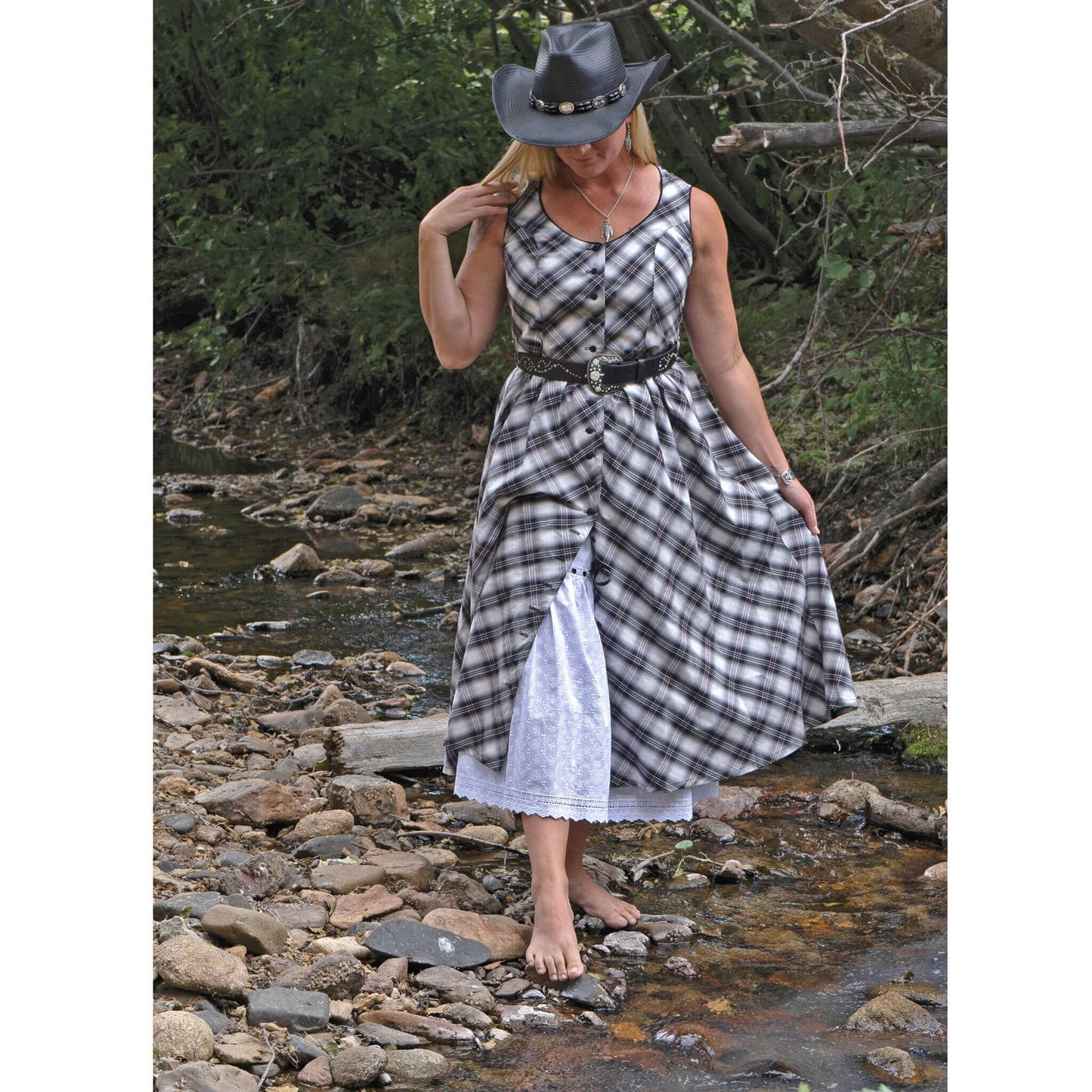 A flirty sundress baring just enough with its button-front and eyelet petticoat (sold separately) peeking out beneath. Contrast piping trims the neckline and armholes and comes with belt loops around the waist to accommodate a cute belt. Dress is made with a bias cut cotton plaid and bodice is lined for modesty. Measures 31” from waist down. 100% Cotton/Lined in Polyester. Petticoat Sold Separately. Made in USA