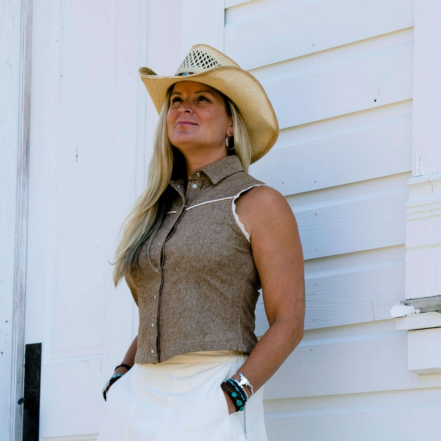This ladies sleeveless western shirt is great for warm rodeo nights or staying cool during country swing nights. The Sierra blouse is made of yarn-dyed lightweight cotton/linen blended fabric. Armholes are finished in delicate lace and the front and black yokes trimmed in a contrast piping. The pearl snaps down the front add the perfect western touch. Made in USA.