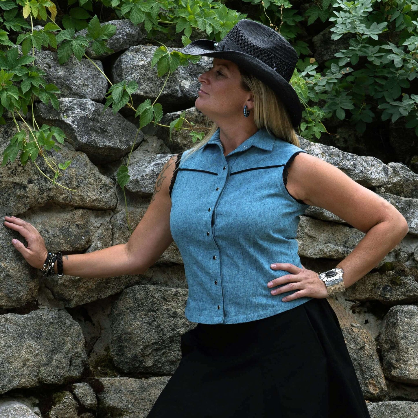 This ladies sleeveless western shirt is great for warm rodeo nights or staying cool during country swing nights. The Sierra blouse is made of yarn-dyed lightweight cotton/linen blended fabric. Armholes are finished in delicate lace and the front and black yokes trimmed in a contrast piping. The pearl snaps down the front add the perfect western touch. Made in USA.