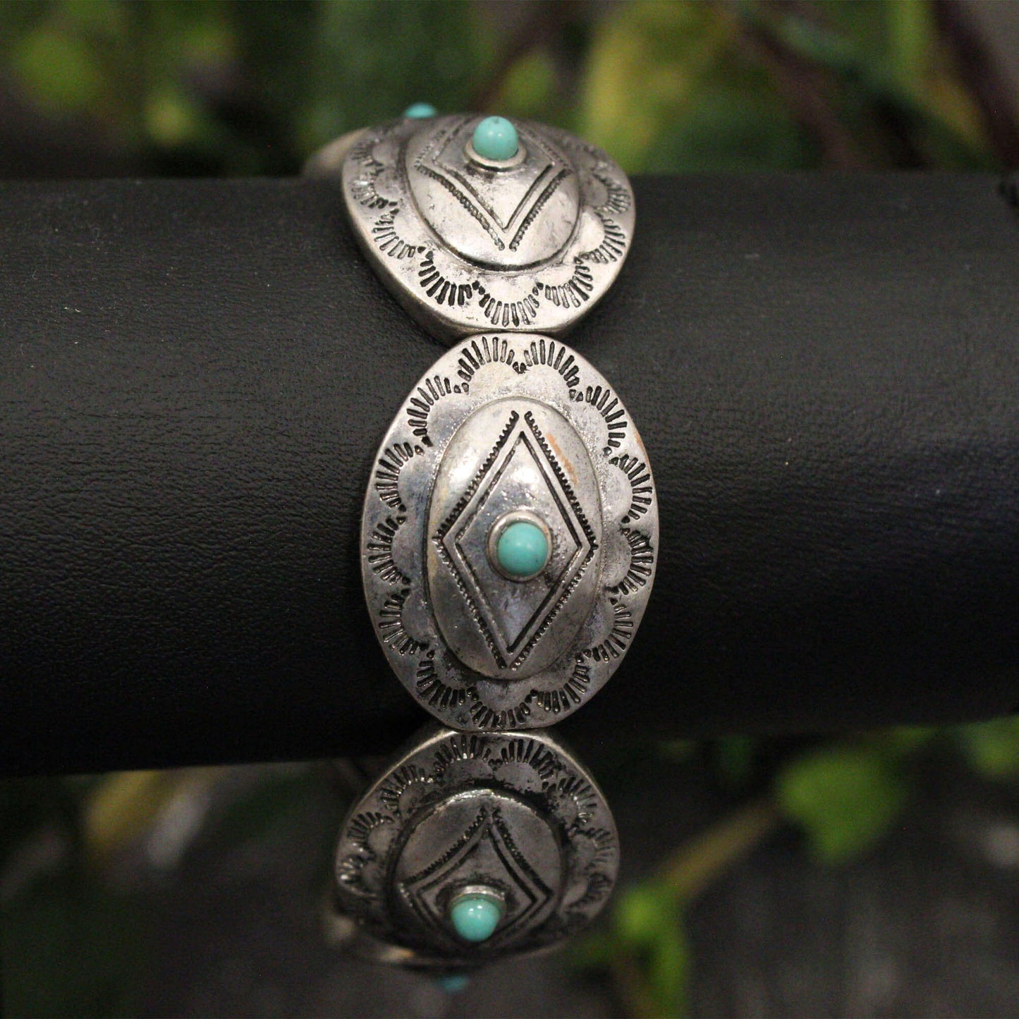 This one-size-fits-most ladies western bracelet features beautifully etched silver Conchos, making it a versatile piece for any occasion. The small turquoise stone adds a pop of color, perfectly complementing your existing western jewelry collection. Wear it alone for a classic look or stacked with other bracelets for a bolder statement. Elastic comfort fit. Conchos measure 1/2" wide.