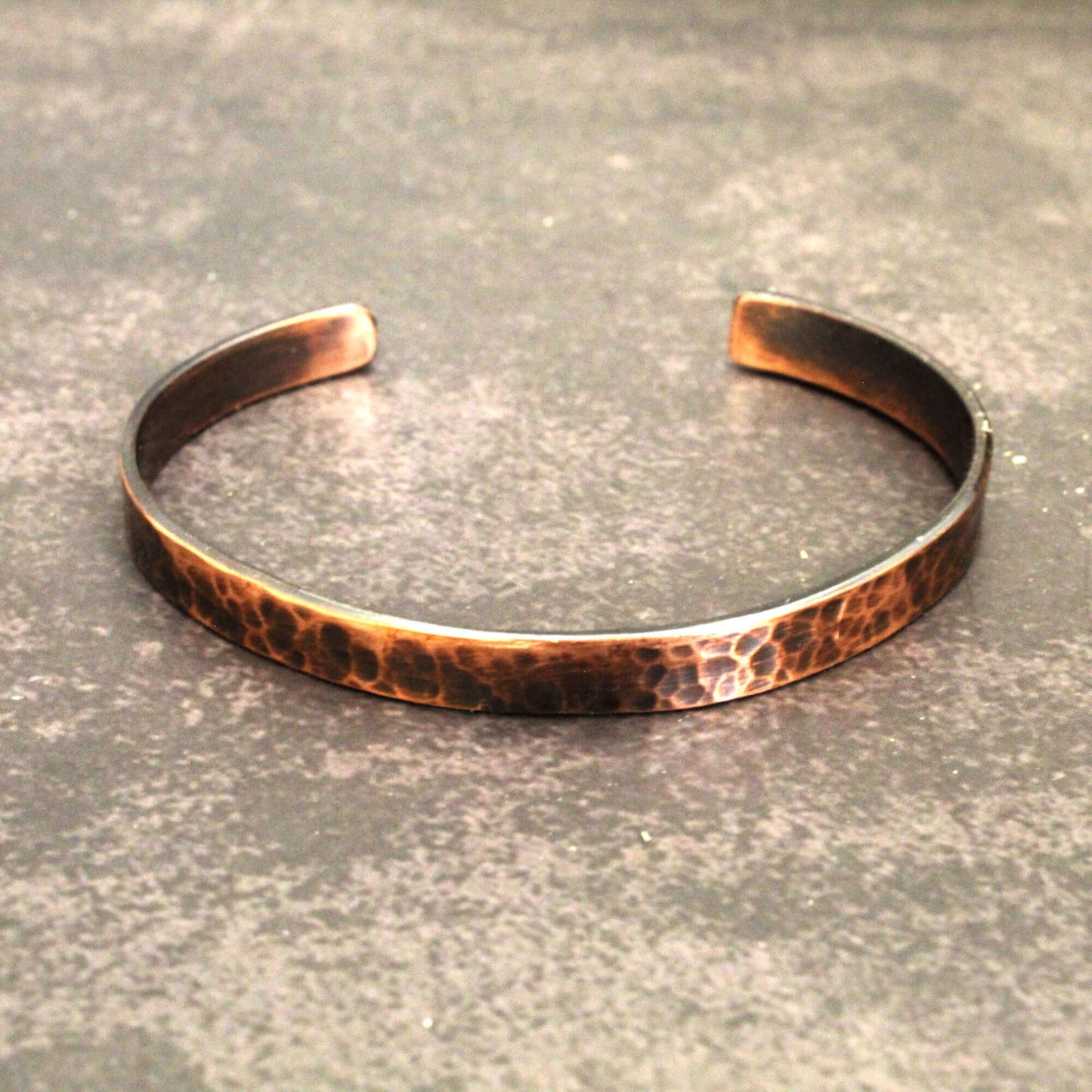 Copper bracelet on a textured gray surface