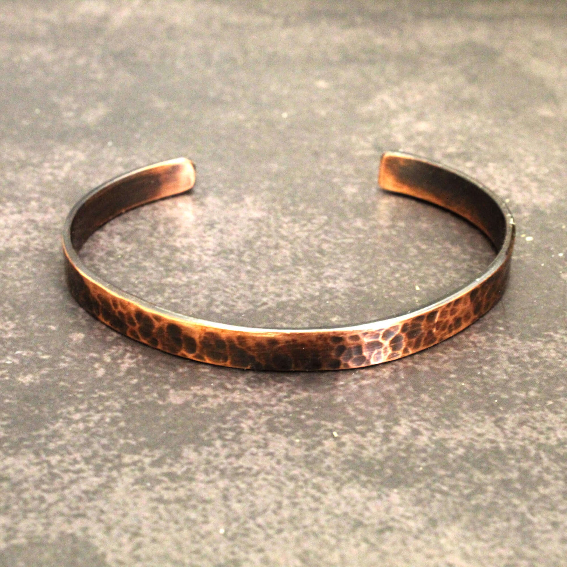 Copper bracelet on a textured gray surface