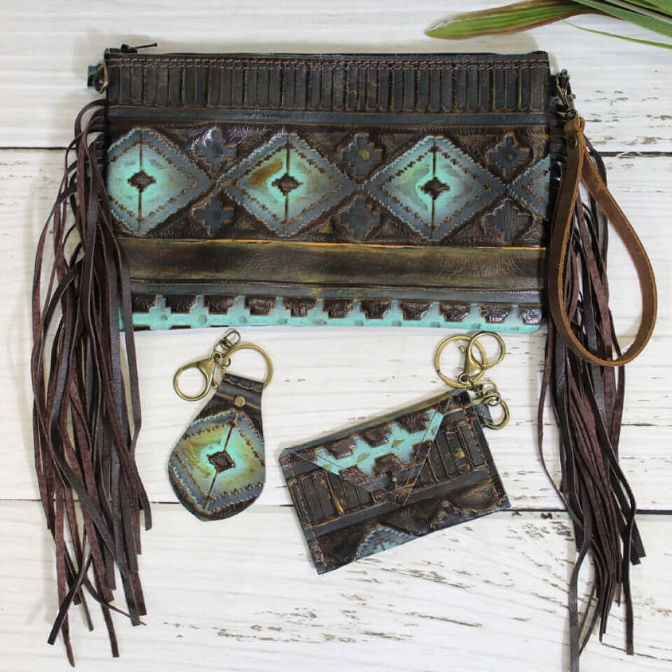 Measuring at 6” x 9”, this clutch offers enough space to carry everything. Made with genuine leather, this gorgeous, one-of-a-kind clutch is unlike any clutch you’ve seen before. Handmade in the state of Texas, each clutch that we design is entirely unique! So, while the clutch that you receive will look similar to the one in the picture, no two purses sold are identical. Fully lined with a zipper closure. Clutch includes two matching accessories. A small card holder and keychain. 