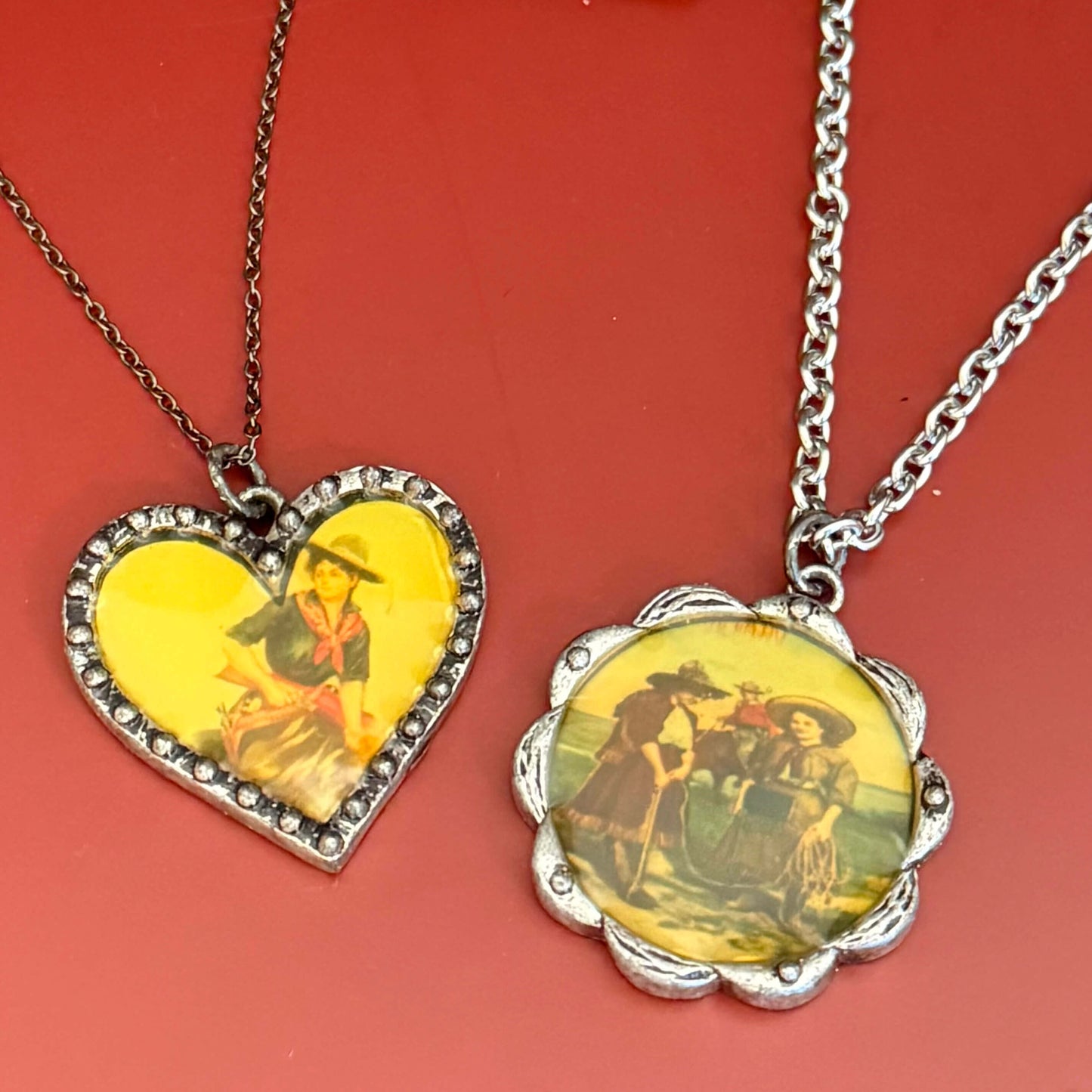 Two necklaces with vintage cowgirl illustrations on a red background.