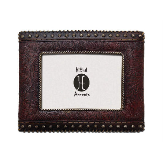 Enhance your western decor with this resign frame featuring tooled faux leather with studded detail on two sides. The scrollwork on the leather, rope border for the photo, and concho studs help to complete a western look on your mantel. Can be utilized with either vertical or horizontal photographs. Back has swing tabs for easy installation, and a thick layer of glass protects your image.