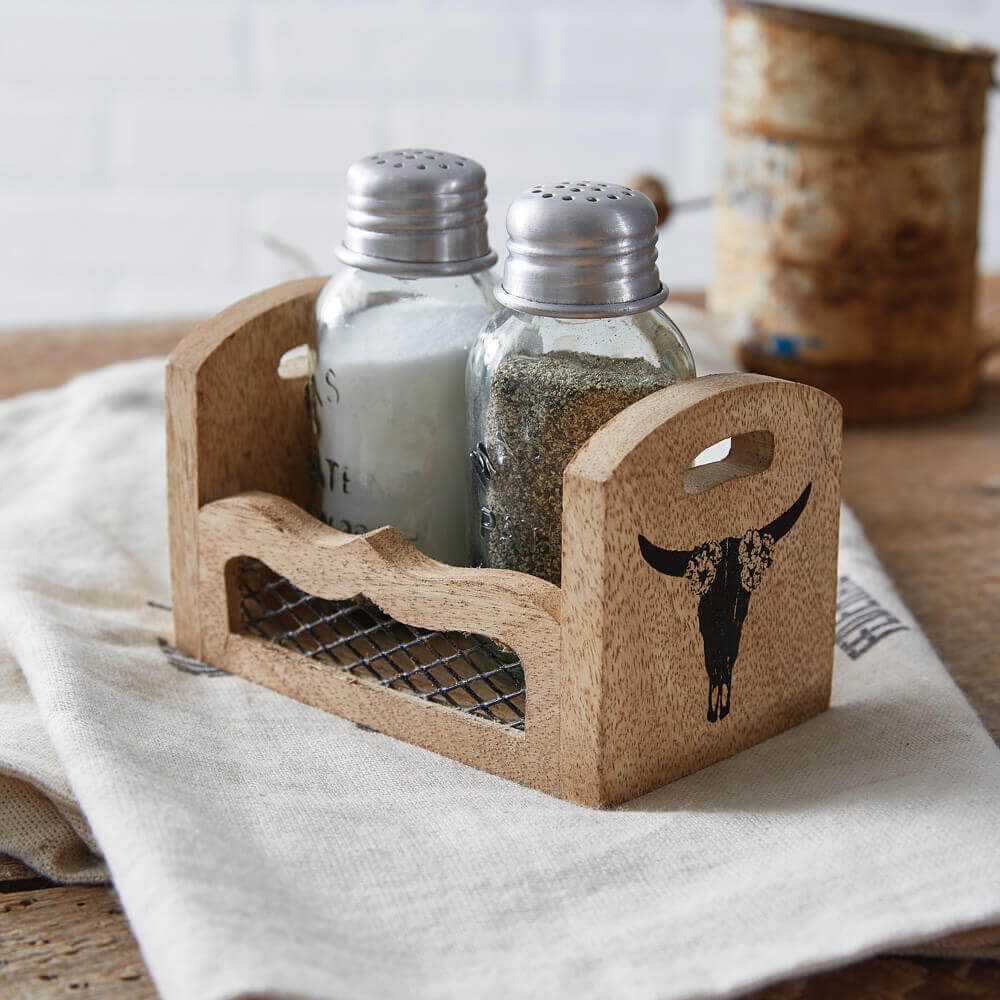 Cork salt and pepper shaker set with decorative bull skull design on a wooden surface.