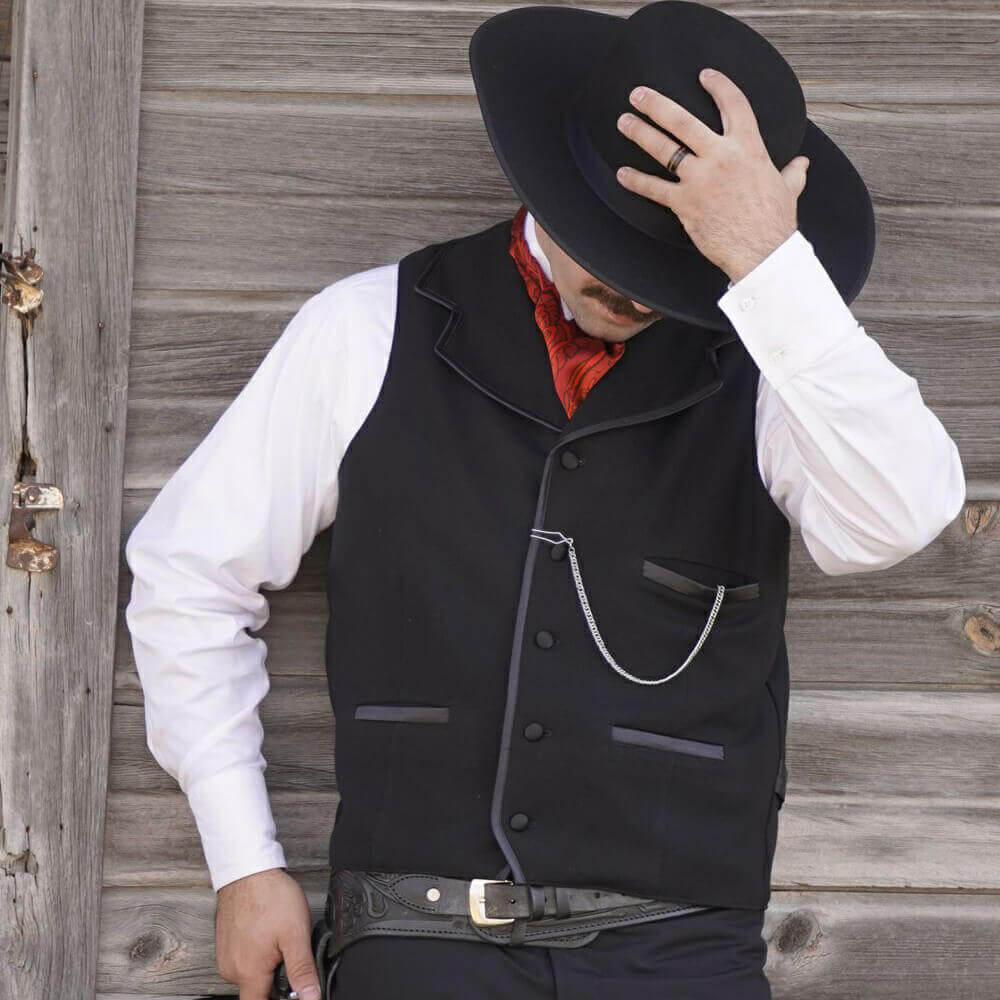 Similar to the vest worn by Kurt Russell as Wyatt Earp in “Tombstone”, this iconic style vest will help you walk the street in confidence. Notched lapels are sewn into the shoulder seam and trimmed in satin bias with three matching satin welt pockets and back belt. Made of 100% wool and lined in polyester. Dry Clean. Made in USA.