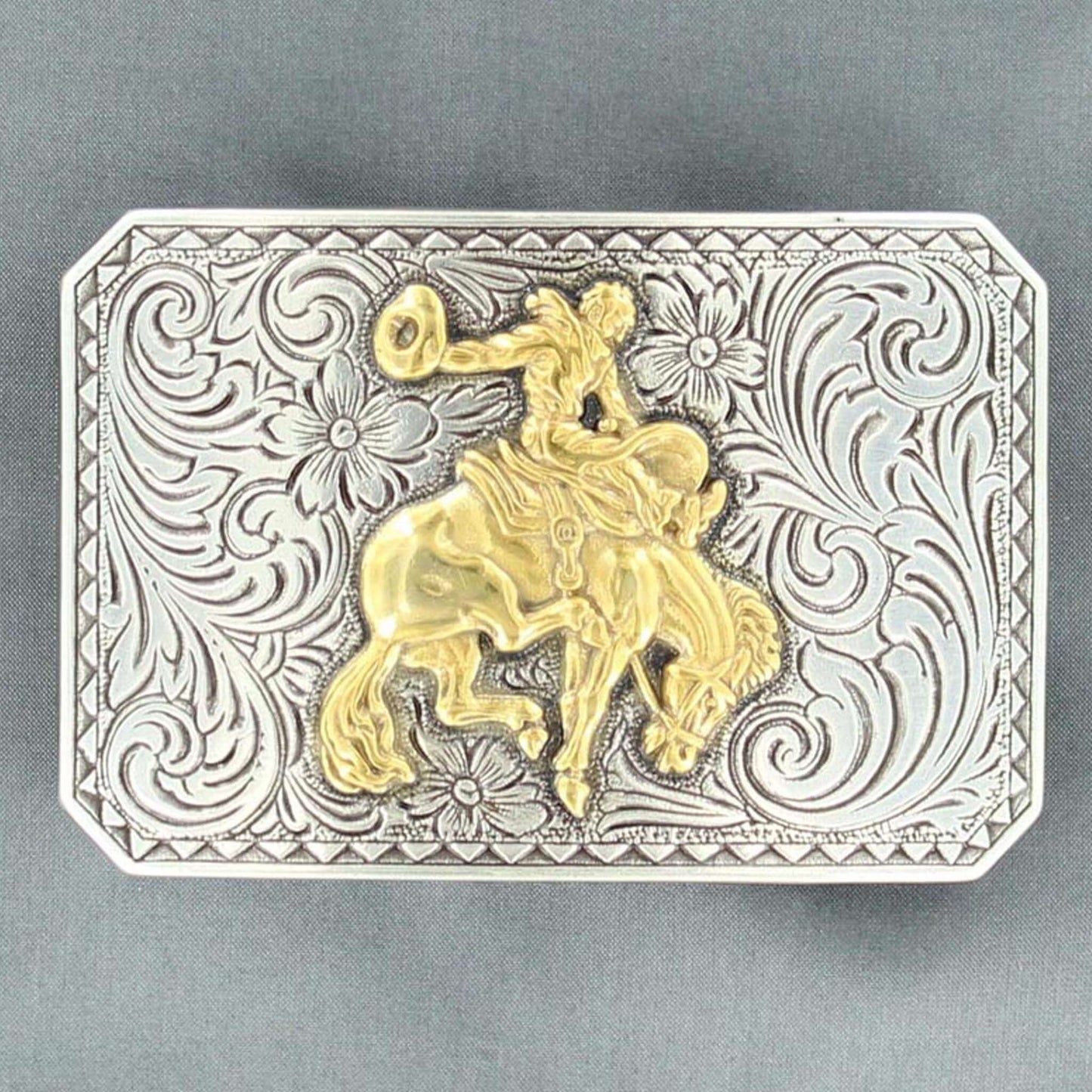 Men's western buckle features a silver floral engraved rectangle shaped buckle with a triangle edge and a gold bucking bronc motif in the center. Measures: 2 X 3. Imported