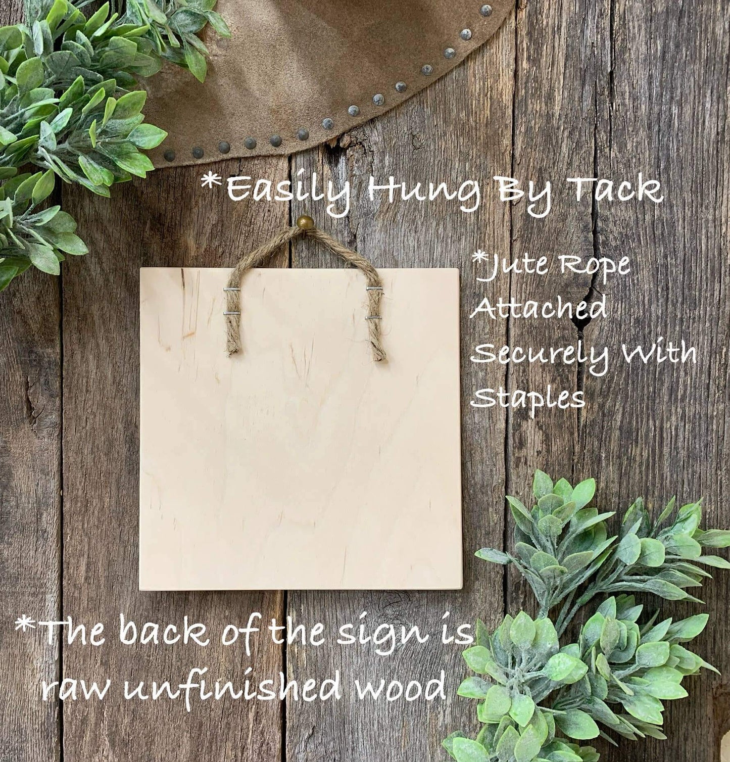 Blank wooden sign with jute rope and greenery on a rustic wooden background