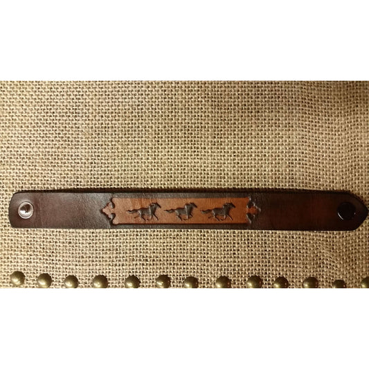 Show your love for horses! This bracelet with running horses embossed on a leather band should do the trick. Measures 7/8" wide and approximately 7" when closed.