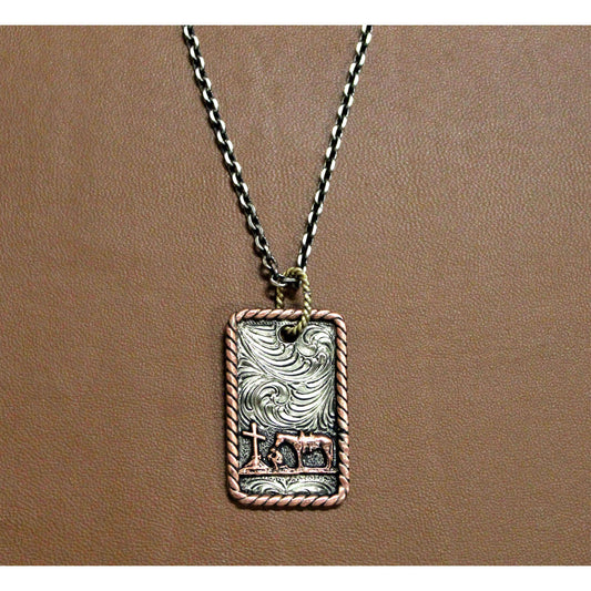 Beautiful antique silver dog tag style pendant with praying cowboy and floral scrolling. Rope edge in antique copper. Sterling Silver plated. 24 inch chain. Imported.