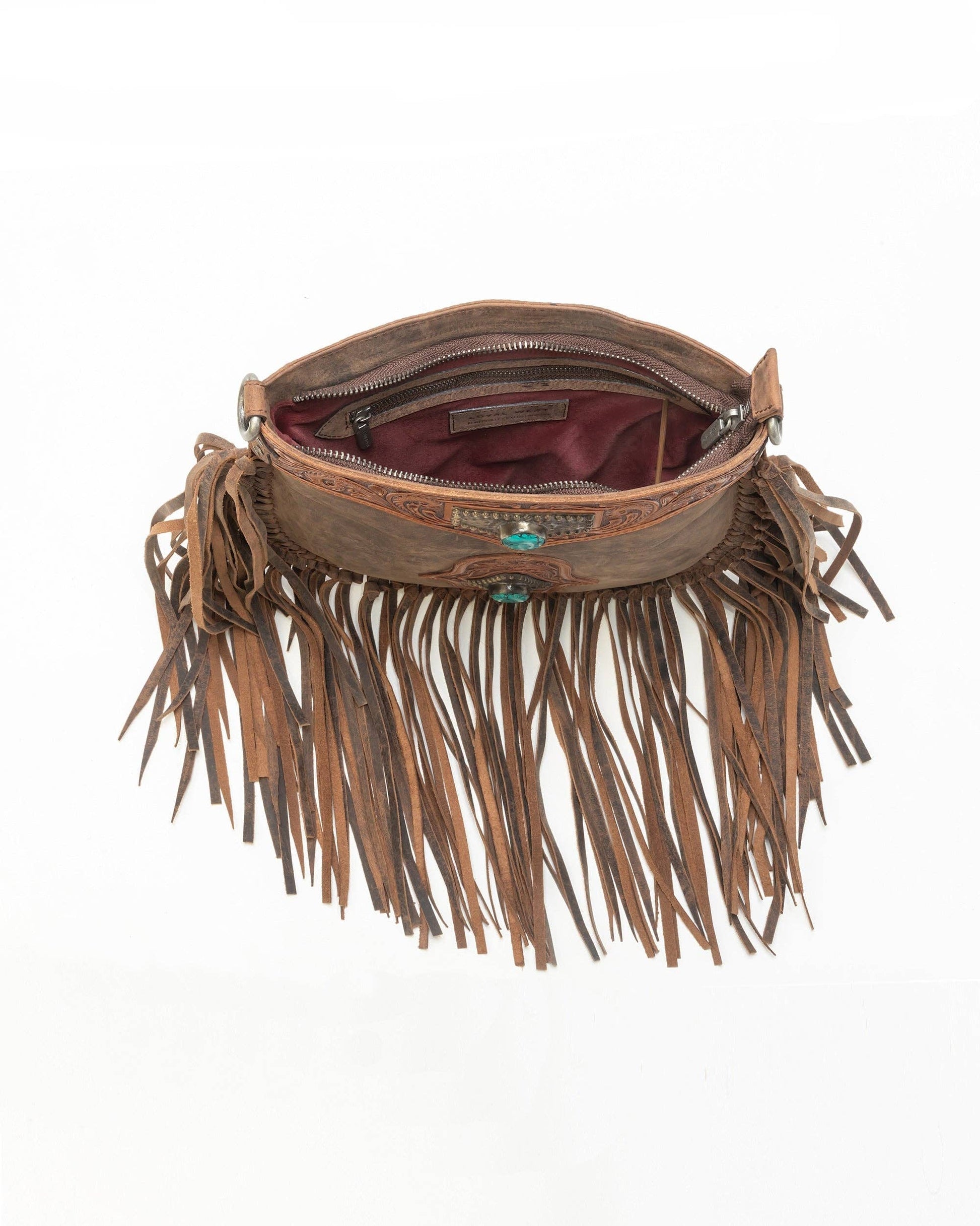 A brown leather fringe bag with a zippered interior, turquoise stone accents, and long hanging fringe, shown against a plain white background.