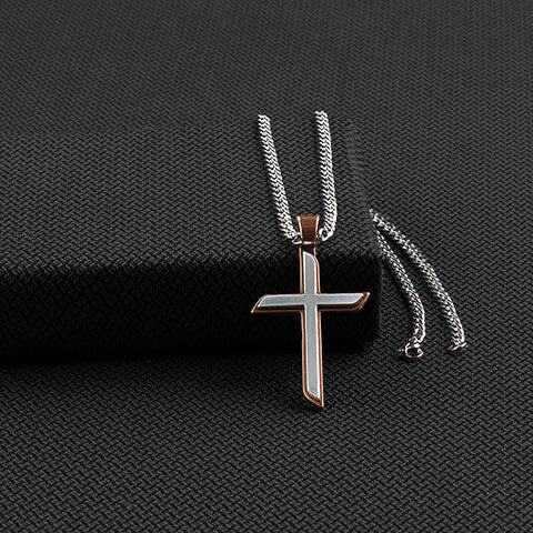 Beautiful two toned copper and antique silver cross pendant that is 2.5” long, that hangs from a 24" stainless chain. The back of the pendant is copper with a floral engraved design. Imported.